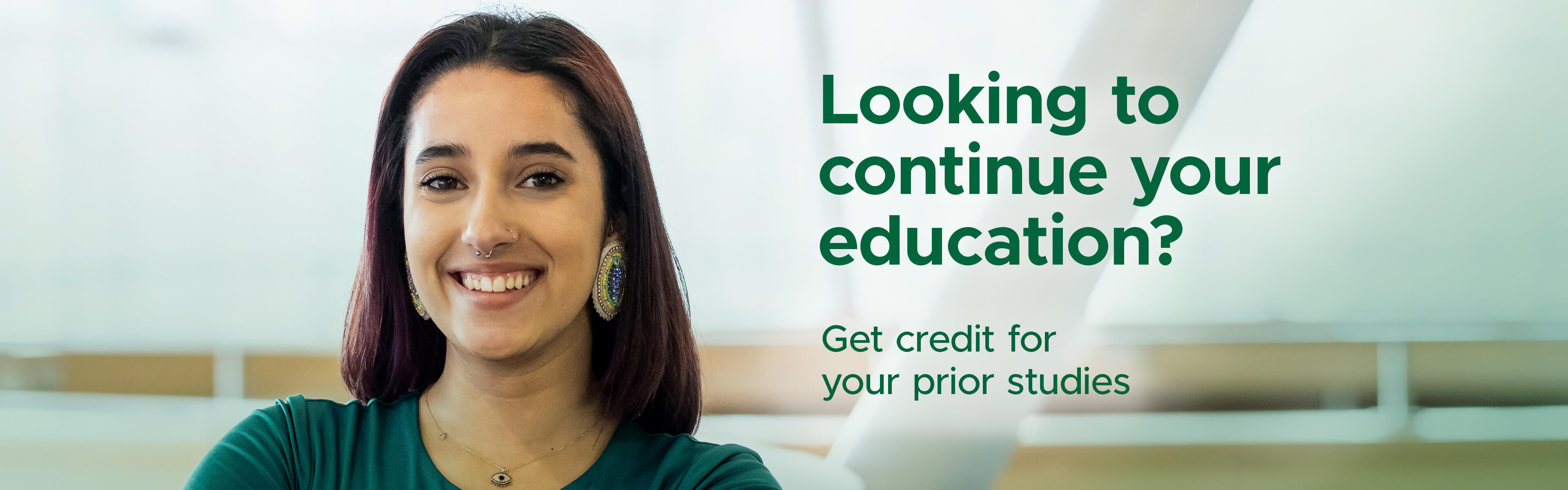 Female student with green shirt smiling at camera.