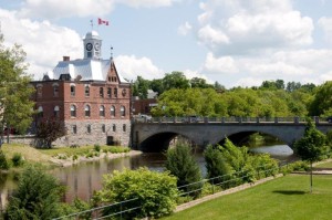 Pembroke City Hall with bridge, parkland, green trees, on a sunny day
