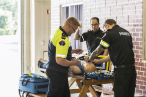 Advanced Care Paramedic students working on simulated scenario with a mannequin