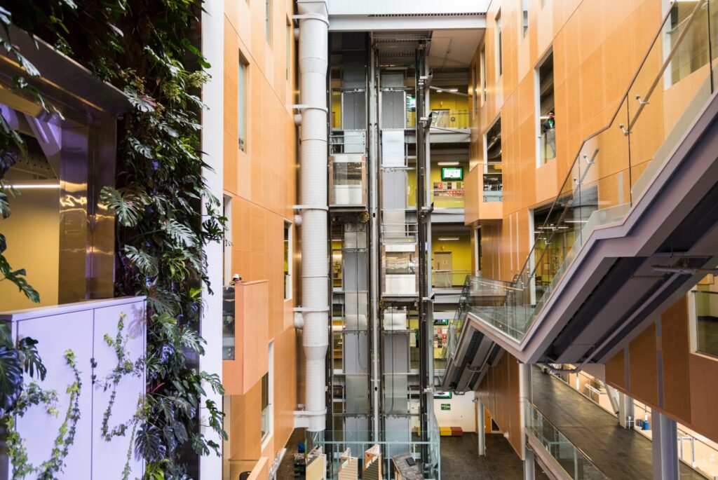 Interior image of ACCE building living green wall, elevators and stairs.