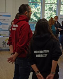 Two professors overseeing the Amazing Youth Worker Race and on the back of their hoodies it says Connecting Your City.