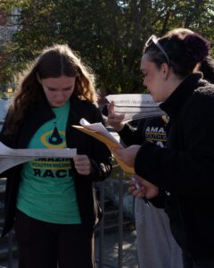 Two students reading the clues for the Amazing Youth Worker Race.