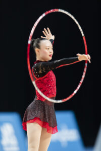 Kimana Mar performs a rhythmic gymnastics routine with a hula hoop.  